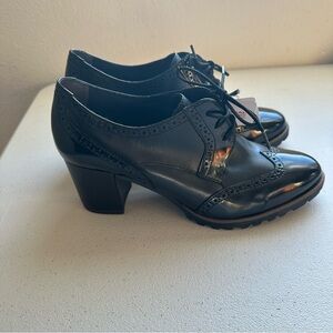 Tamaris black patent lace-up brogue shoes with a low block heel.